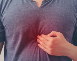 Pessoa com a mão na região do intestino, com refluxo | O que é a Doença do Refluxo Gastroesofágico?